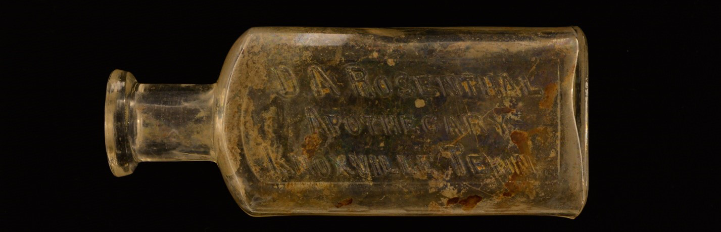 Glass bottle, worn with age, with embossed lettering of D. A. Rosenthal