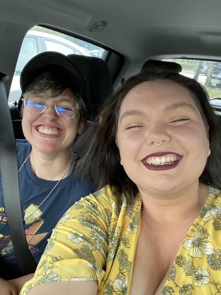 Two smiling people in a car